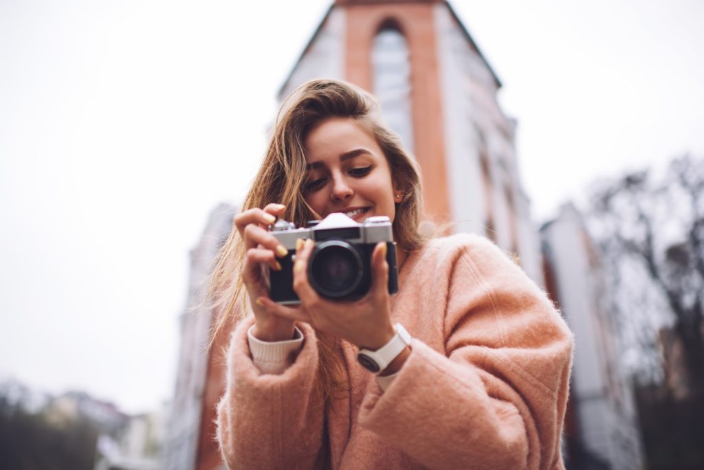 Woman with retro camera taking photo